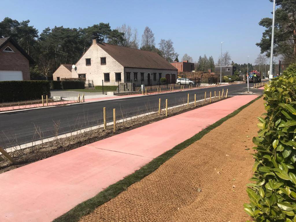 Eerste laag van het asfalt is aangebracht, toplaag moet nog worden aangebracht. Rode betonnen fietspad aangelegd met daarnaast met vernieuwde grachten.